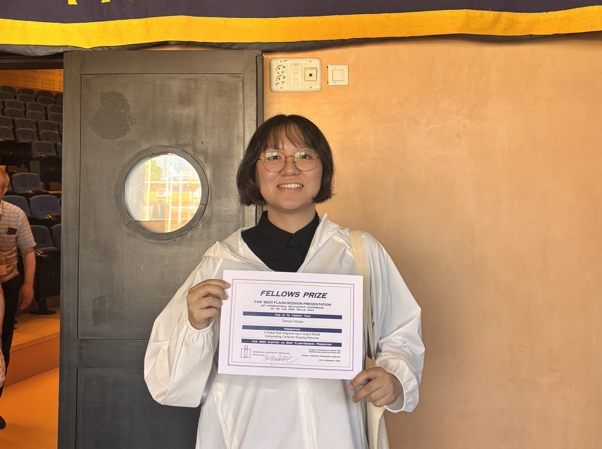 Tomomi Shoda holding her Fellows Prize certificate